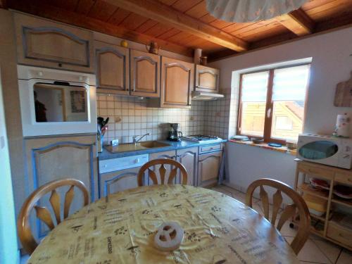 a kitchen with a table and chairs and a table and a table and a kitchen at Appartement chaleureux à Soultzeren avec vue sur montagne in Soultzeren