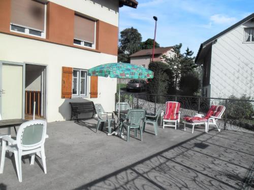 a group of chairs and an umbrella on a patio at Studio convivial à Gérardmer, 35 m² avec vue sur la montagne in Gérardmer