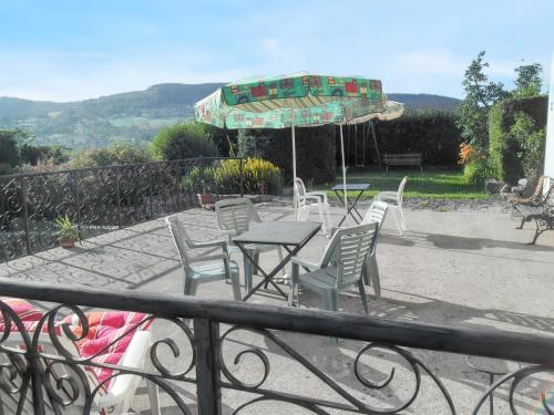 a patio with a table and chairs and an umbrella at Studio convivial à Gérardmer, 35 m² avec vue sur la montagne in Gérardmer