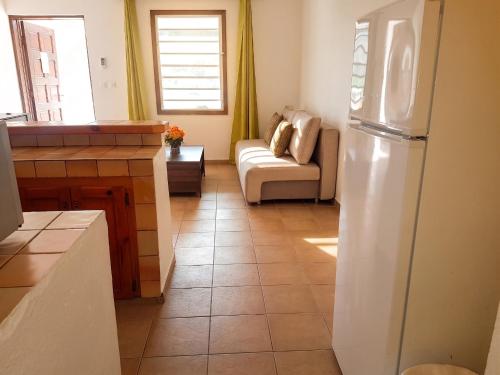 a kitchen with a white refrigerator and a couch at Charming Apartment in La Savane - 65 m² - Terrace with View in Happy Bay