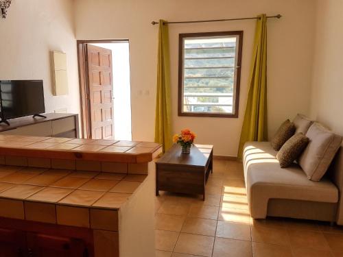 a living room with a couch and a table at Charming Apartment in La Savane - 65 m² - Terrace with View in Happy Bay