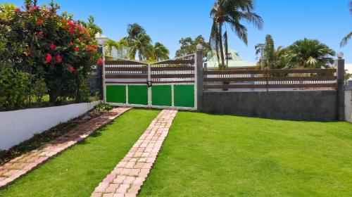 a garden with a fence and grass at Appartement charmant à Baie Mahault avec belle terrasse – 30 m² in Baie-Mahault