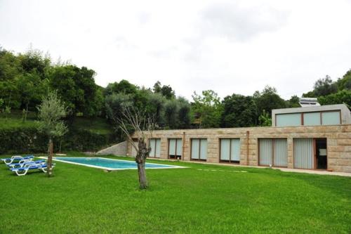 a brick building with a swimming pool in a yard at "Spacious villa in Caniçada with year-round private pool" in Caniçada