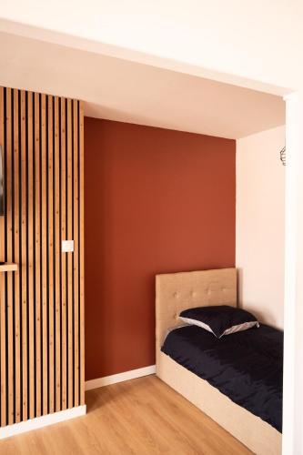 a bedroom with a bed and a brown wall at Le nid bourbourgeois in Bourbourg