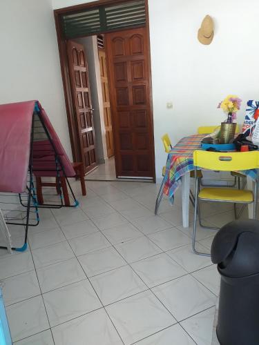 a dining room with a table and chairs and a door at Appartement spacieux à Sainte-Rose - 120 m² - Terrasse ensoleillée in Sainte-Rose