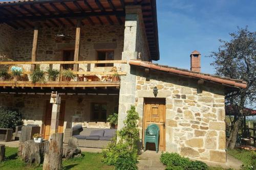 a stone house with a wooden door and a balcony at Charming House in La Cavada with Jacuzzi in La Cavada