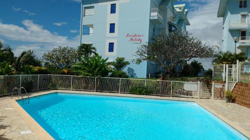 a swimming pool in front of a building at Appartement moderne à Sainte-Anne 43 m² avec vue mer in Sainte-Anne