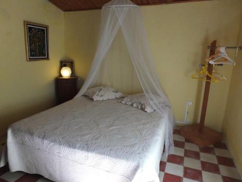 a bedroom with a white bed with a canopy at Appartement raffiné à Feliceto - 120 m² avec vue sur montagne in Feliceto
