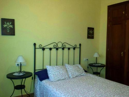a bedroom with a bed with two nightstands and two lamps at Charming apartment with mountain view in Jabuguillo, 70 m² in Aracena