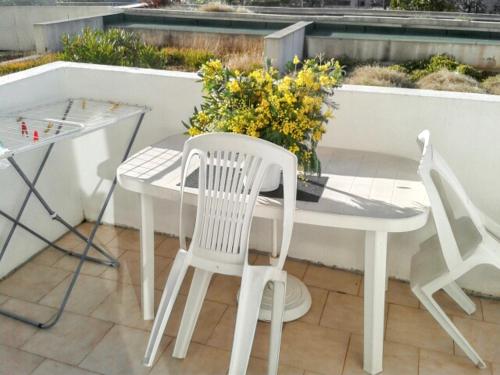 a white table and chairs on a patio at Appartement moderne à Fréjus, 60 m², piscine partagée in Fréjus