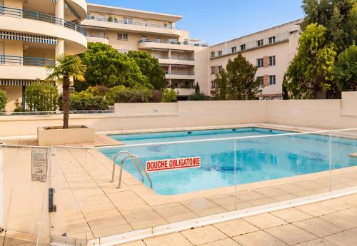 a swimming pool in front of a building at Appartement moderne à Fréjus, 60 m², piscine partagée in Fréjus