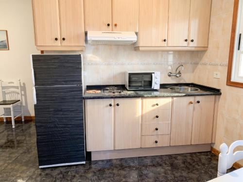 a kitchen with a black refrigerator and a microwave at Modern apartment in Frontera, 45 m² with sea view balcony in Frontera