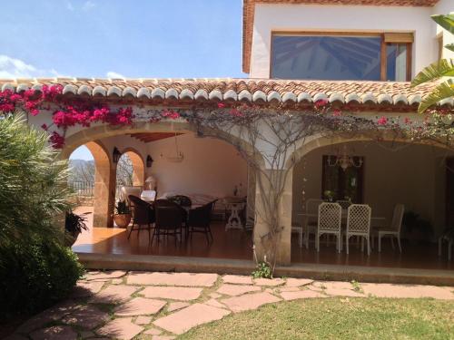 a house with a patio with a table and chairs at Seaside villa in Jávea with private pool in Jávea