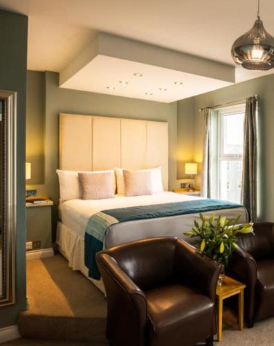 ein Schlafzimmer mit einem großen Bett und einem Stuhl in der Unterkunft Pentire Newquay Cornwall Hotel in Newquay