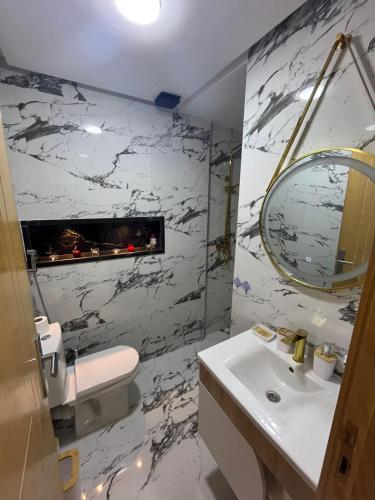 a white bathroom with a sink and a mirror at Flowers in Bouznika