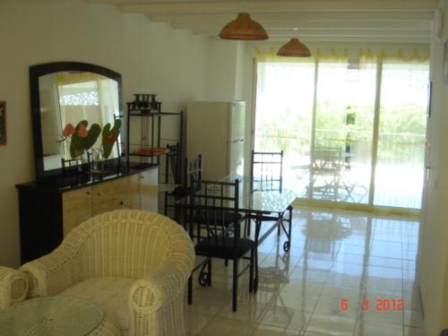 a kitchen and dining room with a table and chairs at Appartement spacieux à Bois des Nèfles, 70 m², piscine partagée in Le Bois de Nèfles