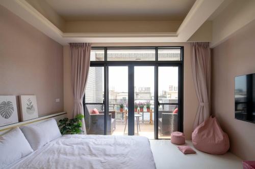 a bedroom with a bed and a sliding glass door at Yuan Lu Homestay in Lukang