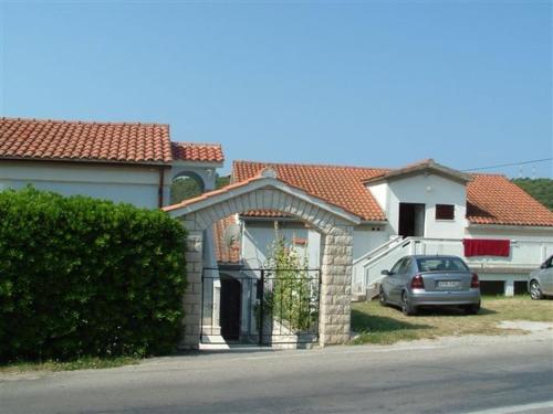 a house with a car parked in the driveway at Charming apartment in Kampor with private garden - 28 m² in Kampor