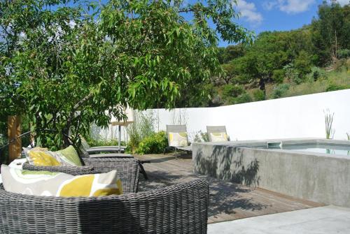a patio with wicker chairs and a swimming pool at Picturesque Villa in Santo António das Areias with Private Pool in Marvão