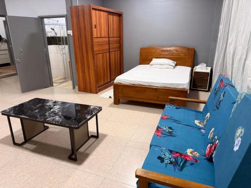 a bedroom with a bed and a table and a couch at Panatina Sunset Residence in Honiara