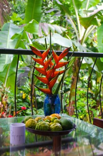 a blue vase with orange flowers on a table with fruit at Charming house in Victoria with mountain view in Victoria