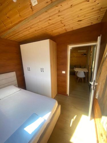 ein Schlafzimmer mit einem Bett und ein Zimmer mit einem Tisch in der Unterkunft Violet Village in Borsh