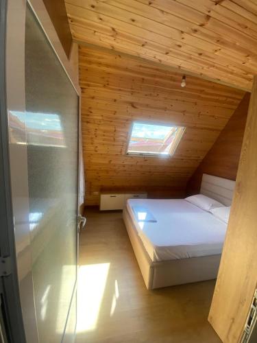 ein kleines Zimmer mit einem Bett in einer Holzhütte in der Unterkunft Violet Village in Borsh