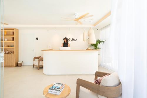 a woman sitting at a counter in a living room at Bauló Mar Apartments in Can Picafort