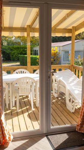 a patio with a table and chairs on a deck at Bungalow charmant à Onzain avec vue sur jardin in Onzain