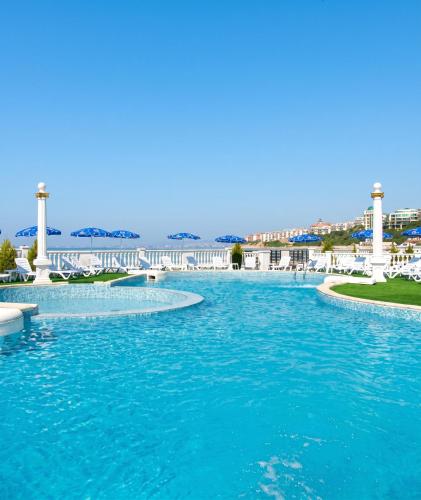a swimming pool with blue water and white chairs at Coastal Studio with Sea View in Elenite, 40m² + Pool in Elenite