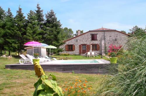a country house with a pool and a pink umbrella at Maison charmante à Saint-Cirq avec piscine privée in Saint-Cirq