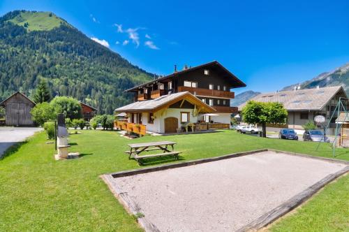 a picnic area in front of a building with a picnic table at Appartement confortable à La Chapelle-d'Abondance 75 m² avec jardin in La Chapelle-dʼAbondance