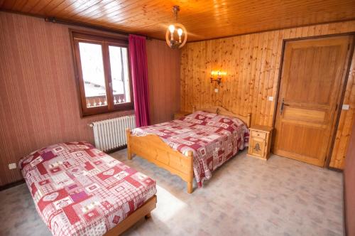 a bedroom with two beds and a window and a door at Appartement confortable à La Chapelle-d'Abondance 75 m² avec jardin in La Chapelle-dʼAbondance