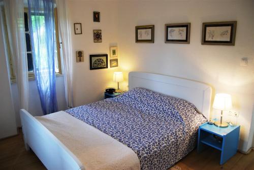 a bedroom with a bed and two tables with lamps at Spacious house in Lukoran with sea view in Lukoran