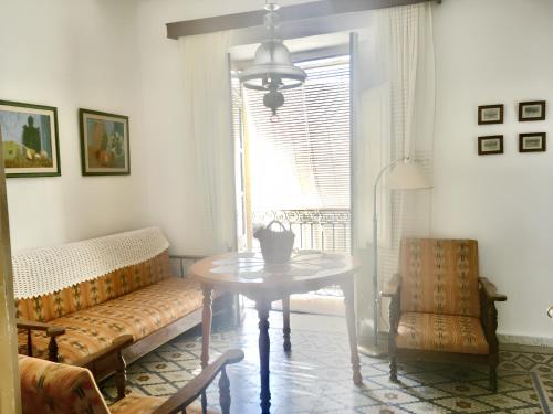 a living room with a table and a couch and a window at Charming Apartment in Albuñol, 90 m², Near Amenities in Albuñol