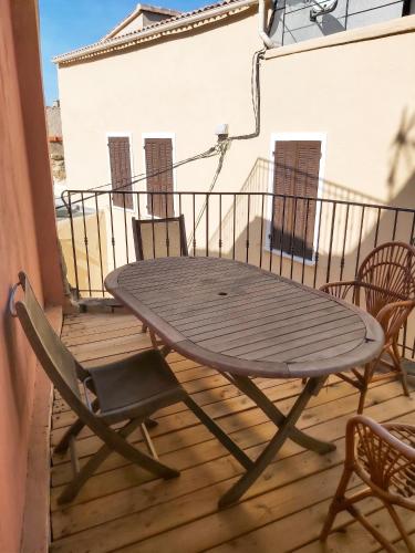 a wooden table and chairs on a wooden deck at Appartement charmant à Algajola avec terrasse in Algajola