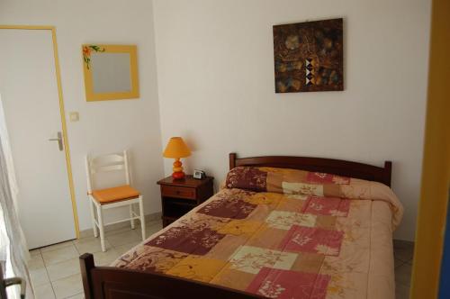 a bedroom with a bed and a table and a chair at Appartement cosy à Valras-Plage / 48m² / Piscine partagée in Valras-Plage