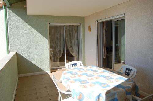 a room with a table and chairs on a balcony at Appartement cosy à Valras-Plage / 48m² / Piscine partagée in Valras-Plage
