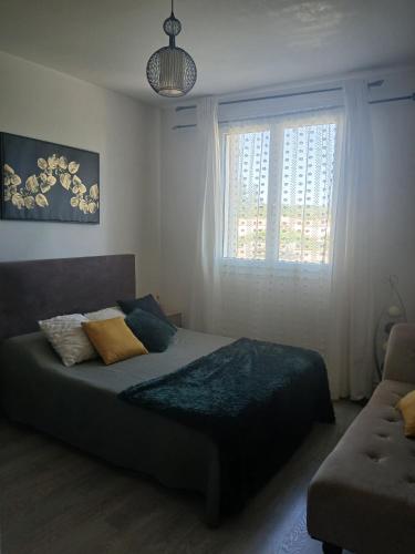 a bedroom with a bed and a window and a couch at les Trois Cœurs in Mison