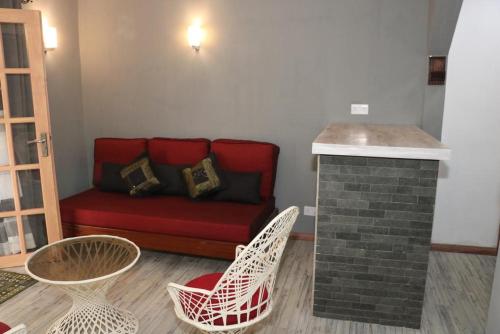 a living room with a red couch and chairs at Charming Studio in Blue Bay, 22 m², Near Beaches in Blue Bay