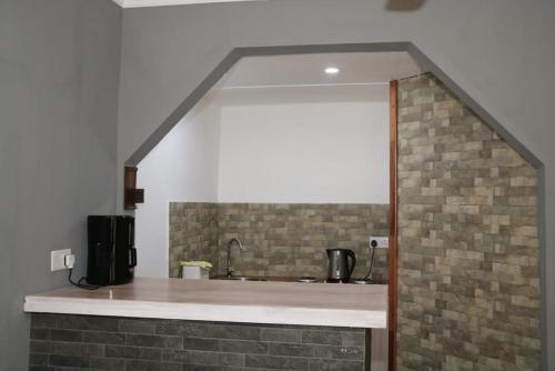 a kitchen with a sink and a brick wall at Charming Studio in Blue Bay, 22 m², Near Beaches in Blue Bay