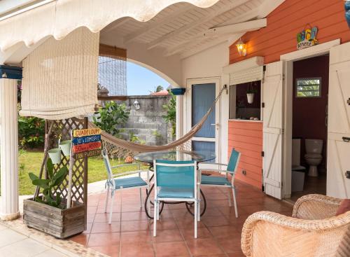 a patio with a hammock and chairs at Studio cosy aux Abymes, piscine et jardin, 25 m² in Les Abymes
