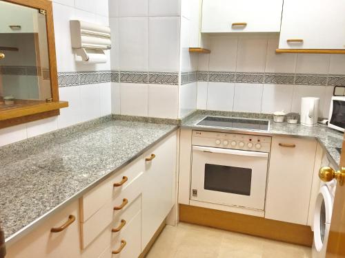 a kitchen with white cabinets and a stove top oven at Modern Apartment in Salou - 50 m² + Pool in Salou
