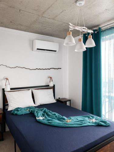 a bedroom with a bed with a blue blanket on it at Alta Vista Apollonia Sunset in Sozopol