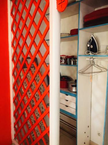 a kitchen with red and blue shelving at Appartement charmant à Basse-Terre - 25 m² avec jardin in Basse-Terre