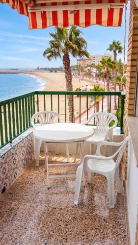a table and chairs on a balcony overlooking the beach at Apartment with pool in Águilas 75 m² with sea view in Águilas