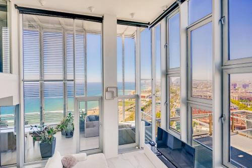 a view of the ocean from a room with glass windows at Penthouse With The Best Views! in Barcelona