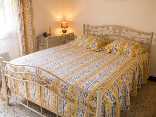 a bedroom with a bed with a yellow and blue comforter at Maison charmante avec vue sur lac à Thil-sur-Arroux in Thil-sur-Arroux