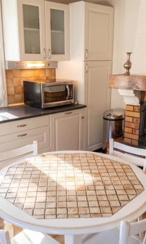 a kitchen with a table and a microwave at Maison charmante avec vue sur lac à Thil-sur-Arroux in Thil-sur-Arroux