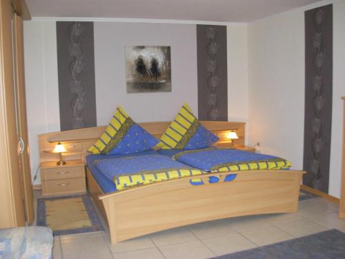 a bedroom with two beds with blue and yellow pillows at Ferienwohnung Steinebach in Daun